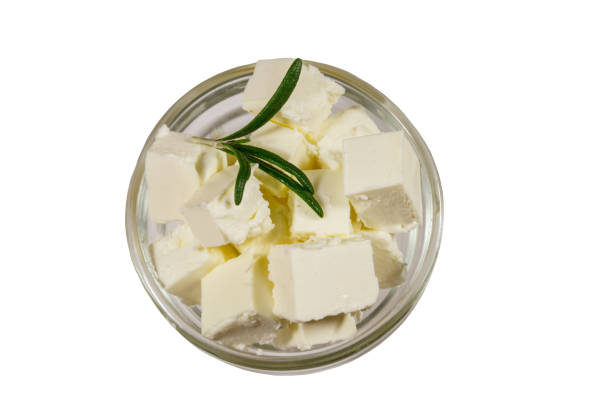Feta cheese cubes with rosemary in glass bowl isolated on white background