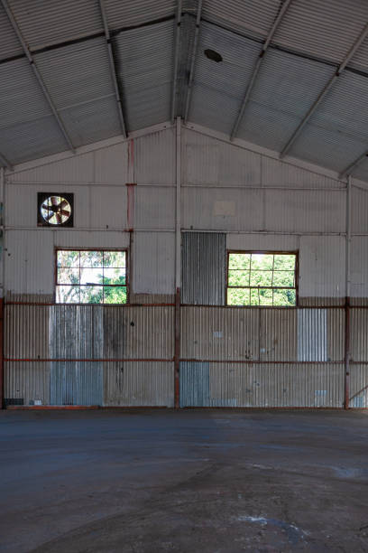 istock Empty warehouse with corrugated tin walls, steel construction and concrete floor 1211406910