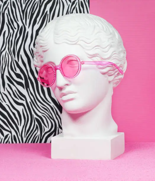 Plaster head model (mass produced replica of Head of an Amazon) wearing pink eyeglasses
