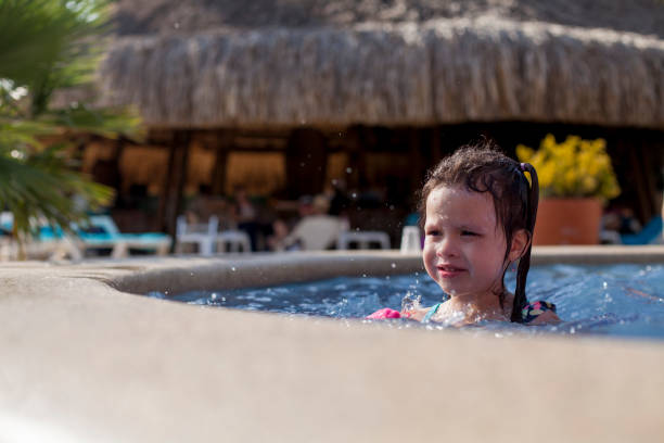 istock Little girl playing in the pool 1211408185