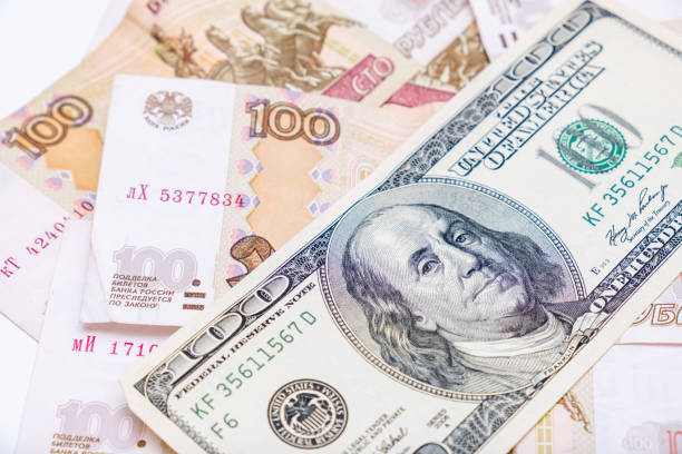 istock Us dollars banknotes lying over russian rubles background, financial crisis and choosing currency for savings, ruble devaluation concept 1211409532