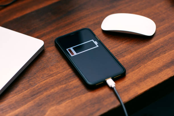 istock A charging smartphone is on the desk，Teak table top 1211411070