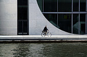 Man on bicycle in Berlin by river Spree, Germany