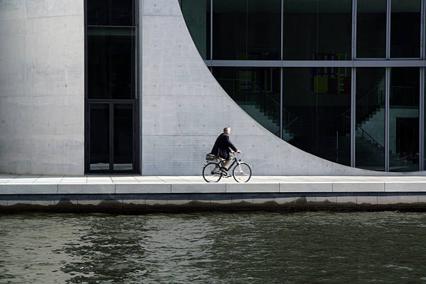 Man on bicycle in Berlin by river Spree, Germany stock photo