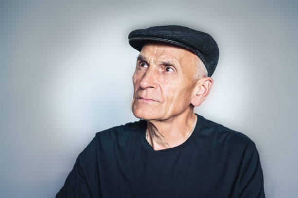 istock Old man in a cap looks into distance 1211414468