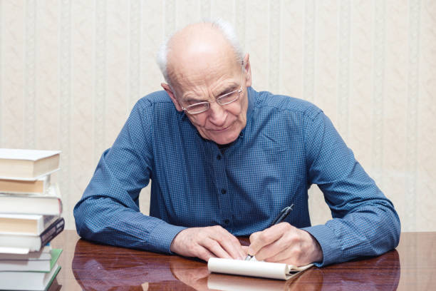 istock elderly man with glasses writes with his left hand 1211414751