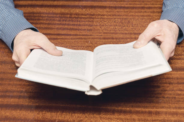 istock open book in hands of old man 1211415174