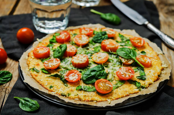 istock Cauliflower pizza crust with tomato and spinach 1211420463
