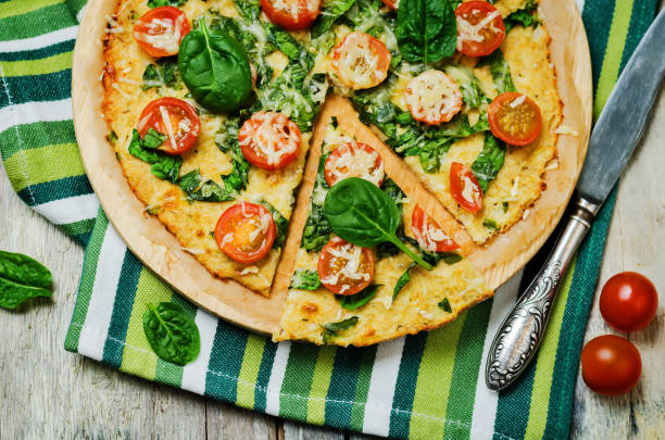 istock Cauliflower pizza crust with tomato and spinach 1211420466