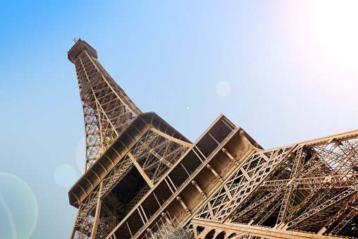 Close low angle view of the majestic Eiffel tower on blue sky background, Paris, France