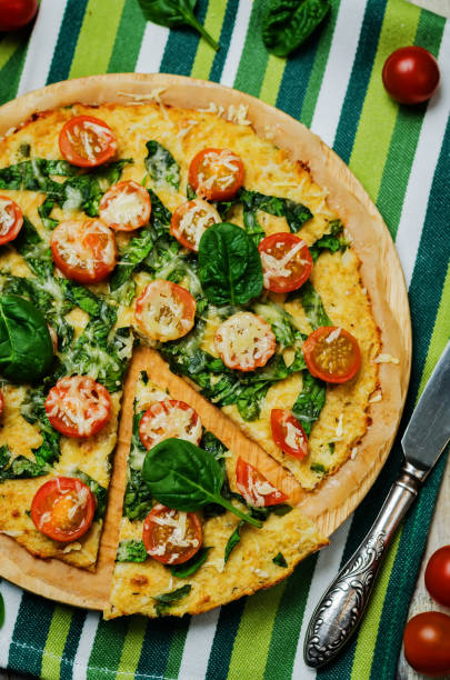 istock Cauliflower pizza crust with tomato and spinach 1211420658