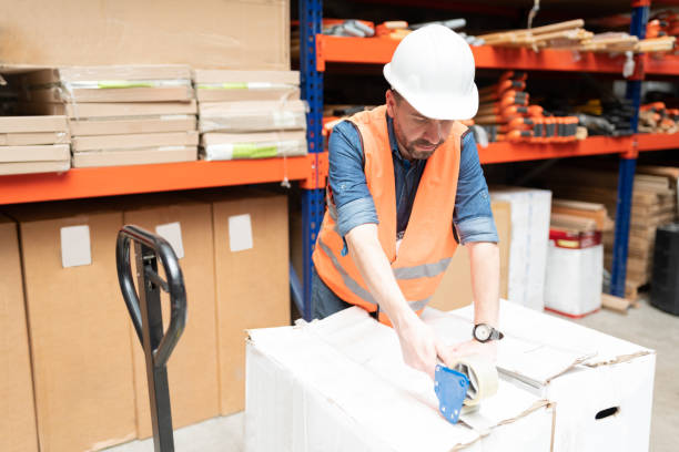 istock Male Latin Employee Sealing Package With Tape 1211421128