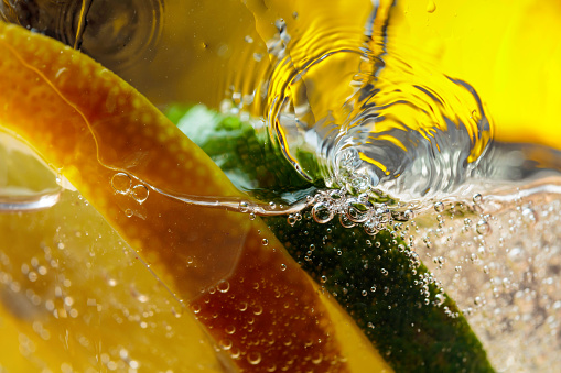 Carbonated drink or cocktail with lemon, abstract splashing. Macro shot.