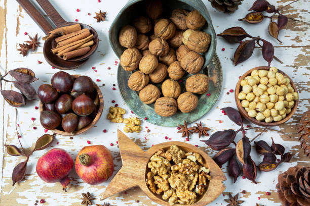 diversi tipi di noci: noce, nocciola, anacardio, arachidi, pino, castagne, mandorle, melograni, cannella, arachidi e altri - chestnut sweet food yellow group of objects foto e immagini stock