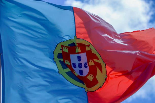 Small paper flag of Portugal pinned. Isolated on white background. Horizontal orientation. Close up photography. Copy space.