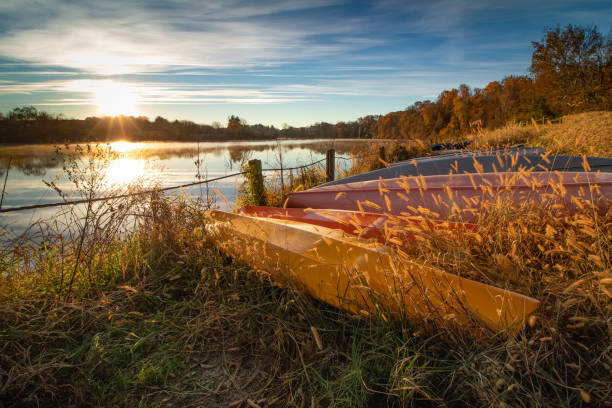 amanecer sobre barcos playados en el lago - november tranquil scene autumn leaf fotografías e imágenes de stock