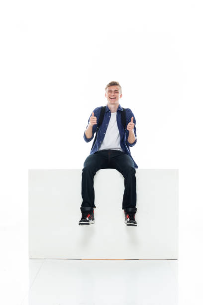 istock Caucasian boys resting in front of white background wearing jeans 1211431488