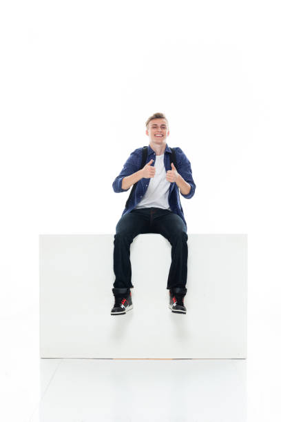 istock Caucasian boys resting in front of white background wearing jeans 1211432630