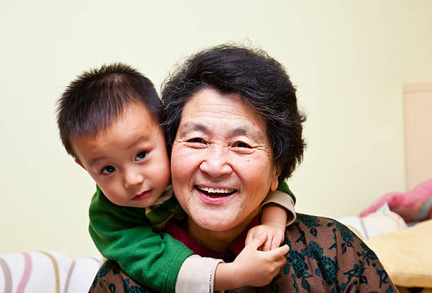 Japanese senior woman, boy and girl relaxed outdoors.