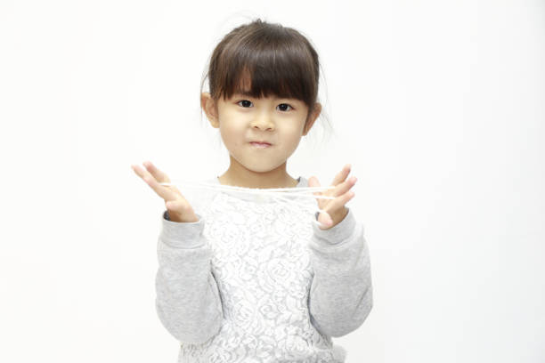 Japanese girl playing with cat's cradle (white back) (5 years old)