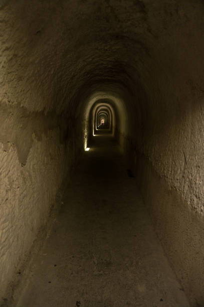 istock Dark tunnel with light in background 1211443791