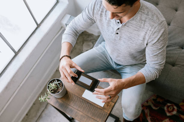 istock Man Makes Remote Online Deposit of Check 1211446528