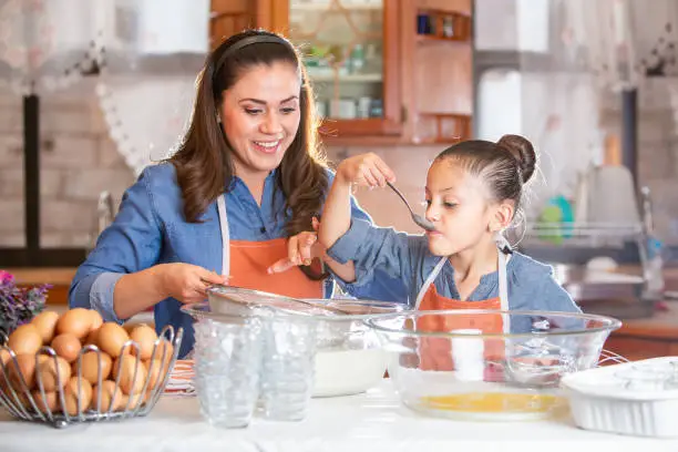 Photo of Mom and daughter preparing a dessert.