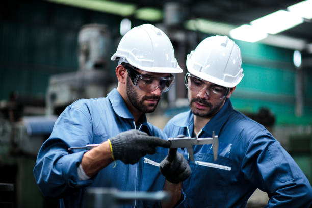 istock Industrial concept. Two workers are working with the machine. Industrial equipment Determined And pay attention to the work being done. 1211450992