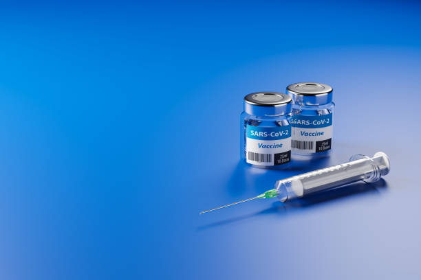 Vaccination against the new Corona Virus SARS-CoV-2: Two glas containers with 10 doses each and a syringe in front. stock photo