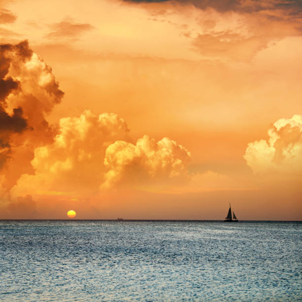 istock orange colored seascape and sailboat 1211455903