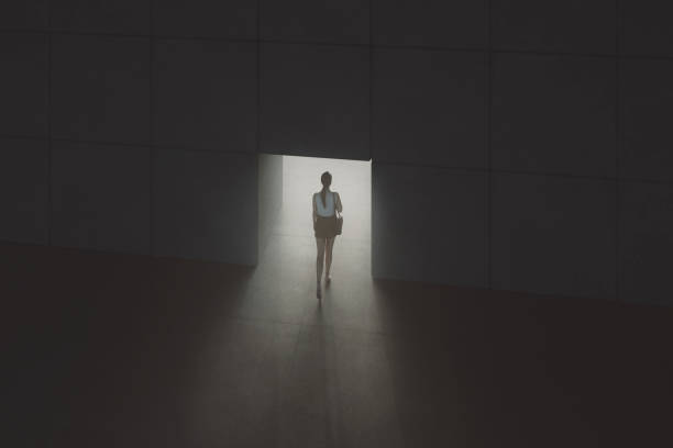 istock Young woman walking through concrete passage 1211456216