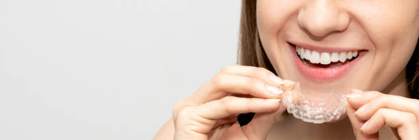 istock Young woman holding invisible aligner 1211458506