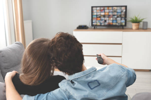 istock Young couple watching TV on sofa 1211458518