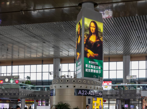 a board using mona lisa painting for advertising a chinese tile brand in huge departure hall of naningnan railway station - mona lisa imagens e fotografias de stock