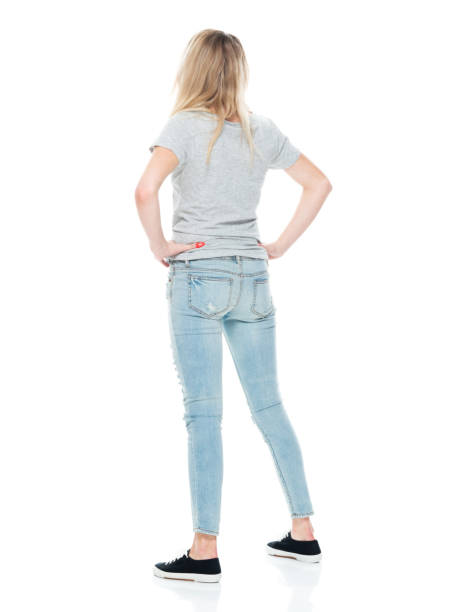 Generation z female standing in front of white background wearing jeans Full length of aged 18-19 years old who is beautiful with long hair generation z female standing in front of white background wearing jeans with hand on hip pics of girls buttocks stock pictures, royalty-free photos & images