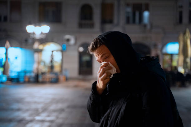istock Young male having running nose, blowing nose with handkerchief 1211468249