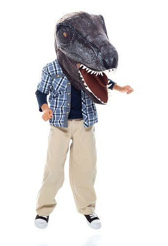 Front view of boys standing in front of white background wearing costume and wearing wearing dinosaur mask mask