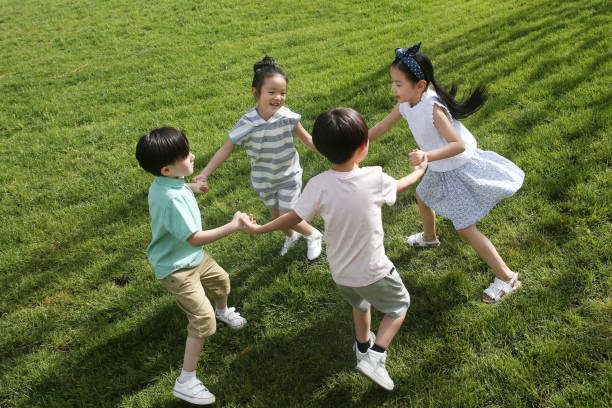 Group Of Children Playing Outdoors Together Holding Hands