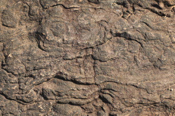istock textures and patterns showing the formation of stone from ancient cooled lava flow on rock faces in a volcanic area rural Victoria, Australia. 1211473493