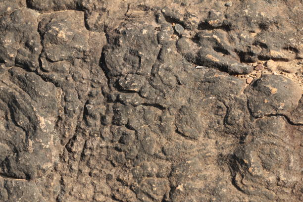 istock textures and patterns showing the formation of stone from ancient cooled lava flow on rock faces in a volcanic area rural Victoria, Australia. 1211473542
