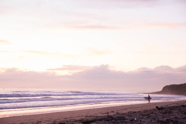 istock Surfer on the beach at sunset 1211492393