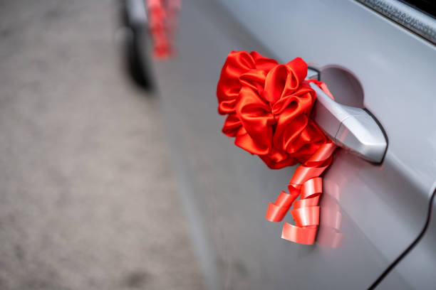 istock Red ribbon decoration on wedding car 1211494794