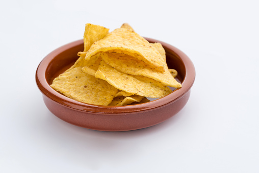 Tortilla chips in wooden bowl on white background
