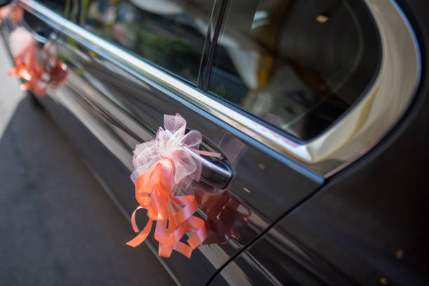 istock Orange ribbon decoration on wedding car 1211495582