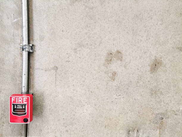 istock Gray aged  Concrete Cement wall with fire alarm button. 1211495657