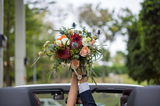 Wedding bouquet with eustoma, orchids, bellflowers, peonies and wildflowers in boho style on a bright background