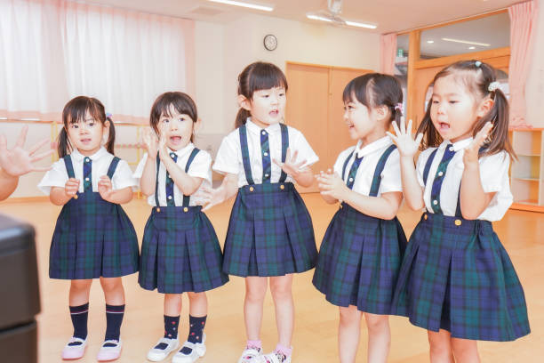bambini che cantano in un asilo - toddler music asian ethnicity child foto e immagini stock