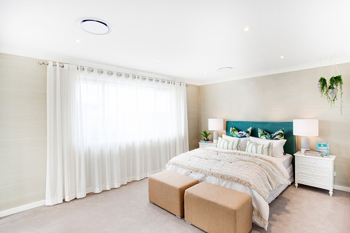 En casa dormitorio moderno con sábanas blancas y cortina blanca photo