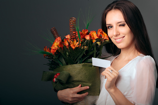 Winking  girl receiving beautiful flowers from her loved one