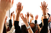 Voting audience, business spectators or students raising hands in seminar